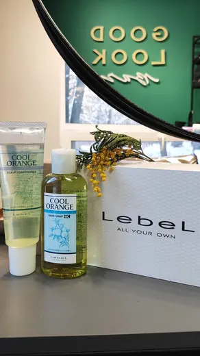 Круглая вывеска GOOD LOOK и косметика Lebel на стойке